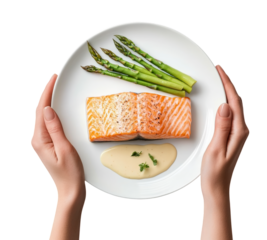 Delicious grilled salmon fillet with asparagus and sauce served on a white plate transparent background