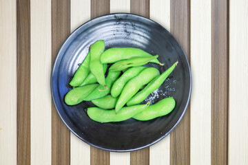 Top view of Fresh green peas on black plate, focus selective