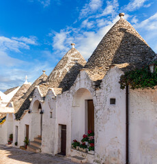 beautiful pretty vintahe houses with blue cloudy sky on background. old mediterranean home for dwelling. buildings of trulli with traditional shapes and style