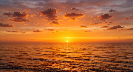 Obraz premium Golden hour bathes the sea in warm light under a sky of orange clouds