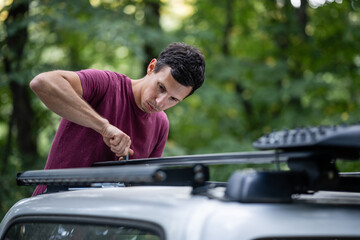 Mechanic installing roof rack on car in forest © Zoran Jesic