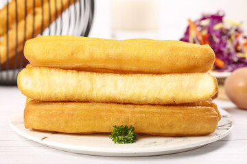 Crispy big fries piled on a shallow plate with fresh vegetables and a creamy dip in a cozy dining setting