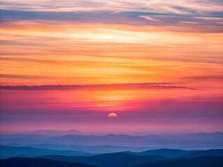 Vibrant sunset gradient over layered blue mountain ridges clouds orange