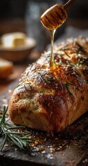Honey-drizzled rosemary bread loaf on a rustic wooden board