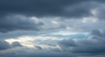 Textured and layered cloud formations in shades of grey and blue, perfect for a moody sky background.

