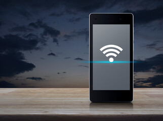 Wi-fi connection flat icon on modern smart mobile phone screen on wooden table over sunset sky,...