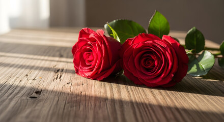 Two Red Roses Lying on Weathered Wooden Table With Soft Shadows and Morning Light Filtering Through Nearby Window