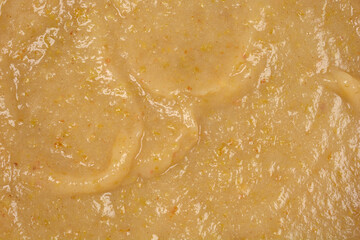 A detailed close-up, full-frame view of cooked mashed apples for apple pie, showcasing their smooth texture and subtle variations