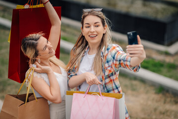 Two happy women taking selfie after shopping spree