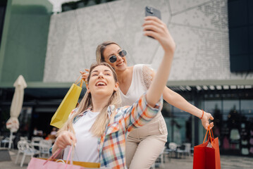 Two happy women taking selfie after shopping spree