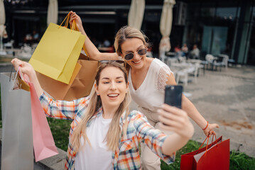Two happy women taking selfie after shopping spree