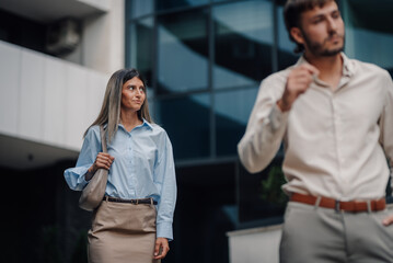 Businesswoman walking in the city while businessman passing by her