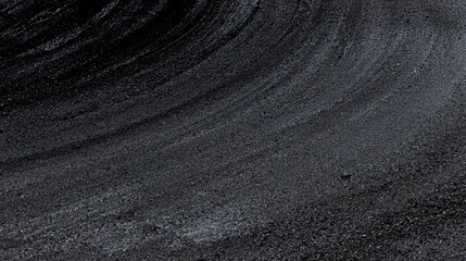 A textured black and white image of a road with tire tracks.