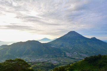 Panoramic view of mountainous landscapes, with a prominent volcanic peak dominating the horizon,...