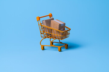 Cardboard boxes in a trolley on blue background,concept of online shopping and e-commerce...