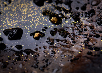 Closeup Gold on grungy wash pan with river sand. Gold digging discovery