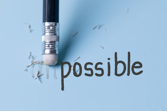 Changing the word impossible to possible with a pencil eraser.Examination for fix and correct or change some incorrect and problem in business concept.