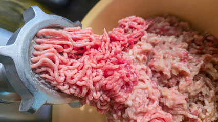 Meat grinder with fresh minced meat on the kitchen table Close-up of minced meat