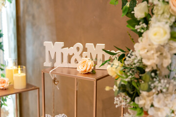 A beautifully arranged wedding décor showcases a Mr. and Mrs. sign surrounded by delicate flowers...