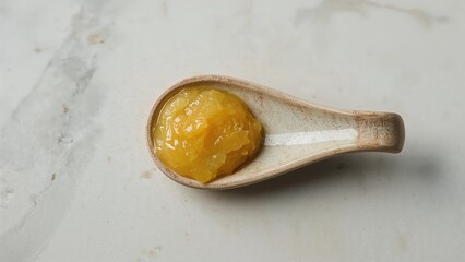Close-Up of Natural Honey on Ceramic Spoon with Yellow Texture for Healthy Cooking and Culinary Nutrition