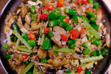 dry pot bullfrog with green and red chili peppers. top down view