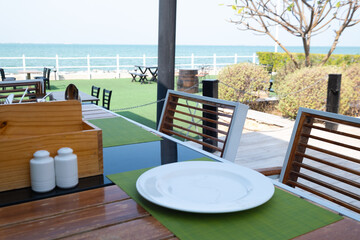 Fine dine seafood restaurant at the beach, white ceramic plate on restaurant table