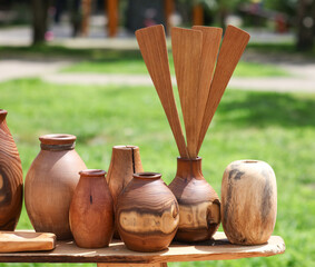 A collection of wooden vases and a wooden spoon are displayed on a table