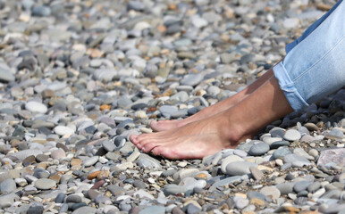 A person is sitting on a beach with their feet in the sand