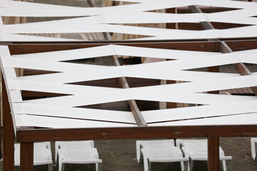 A wooden structure with white stripes and a white roof