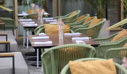 A restaurant with a lot of green chairs and tables