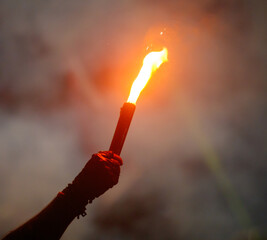 A person holding a lit torch