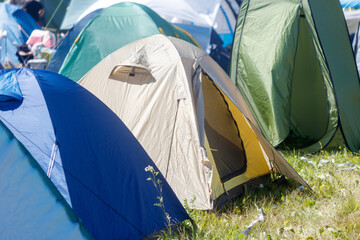 A group of tents are set up in a field, with one of them being a large tent