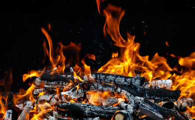 A pile of burning wood with a lot of smoke and fire