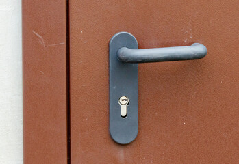 A black and silver door handle with a keyhole