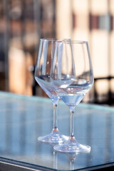 Two elegant wine glasses are perfectly placed on a glass table