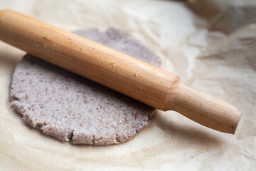 A rolling pin is used to roll out dough in the kitchen