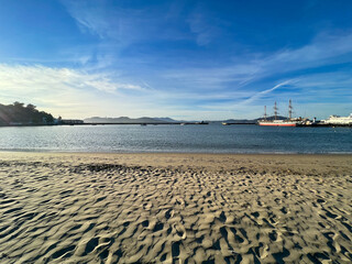 A beach with a large ship in the water