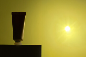 Minimalist silhouette of a sunscreen tube glowing under intense sunlight. A conceptual...