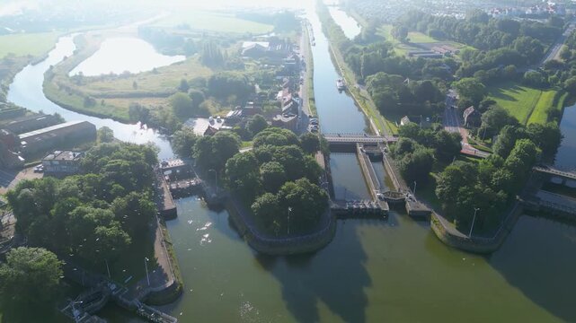 Aerial view of the locks and waterways, reflecting the sky, contrasting with the green trees, Nieuwpoort, Belgium.