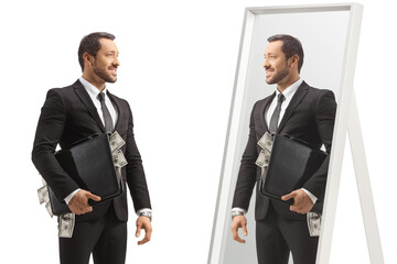 Businessman standing with a briefcase full of money and looking at a mirror