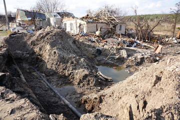 A destroyed house and damaged communications after an air strike. A village in a combat zone. War in Ukraine.