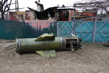 A large rocket fell near a house in a rural area. The bomb destroyed the house. A dismantled shell lays on the road.