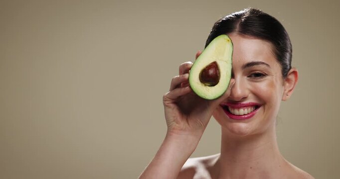 Skincare, beauty and woman with avocado in studio for natural, glow or moisturizing benefits. Cosmetic, mockup space and person with fruit for dermatology routine with hydration by brown background.