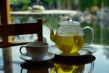 Steaming Cup of Herbal Tea Next to a Traditional Japanese Iron Teapot