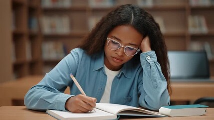 Student, concentration and stress with homework in library for exam preparation, education pressure and academic deadline. Teen, writing notes and study with focus, fatigue and school challenge - Powered by Adobe