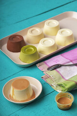 A vibrant and colorful overhead shot captures a variety of smooth, dome-shaped puddings, including...
