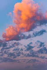 Stunning sunset paints the clouds with vibrant hues of orange and pink, creating a breathtaking spectacle in the vast expanse of the twilight sky
