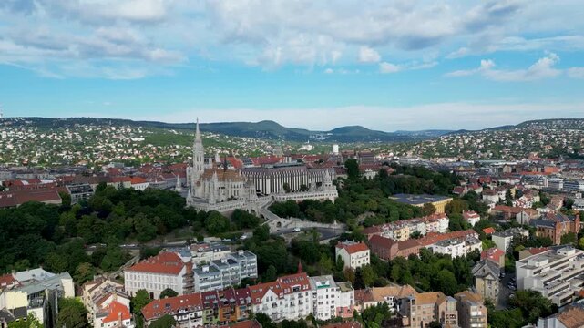 Aerial view of Matthias Church and the cityscape, a blend of architectural grandeur and urban sprawl under a sky, Budapest, Hungary.