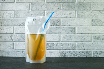 Lemon beer in plastic bag. Convenient format for adult alcoholic drink on walk. Spill-Proof pouch. Alcohol drink with drinking straw