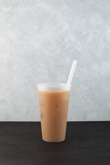 Chicory ersatz coffee or New Orleans iced coffee. Iced chicory latte in disposable plastic cup. Refreshing cold drink. Take away street food beverage